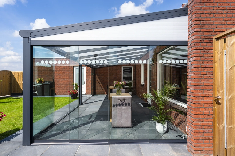 Nowoczesna pergola tarasowa z przesuwnymi szklanymi panelami przy ceglanym domu