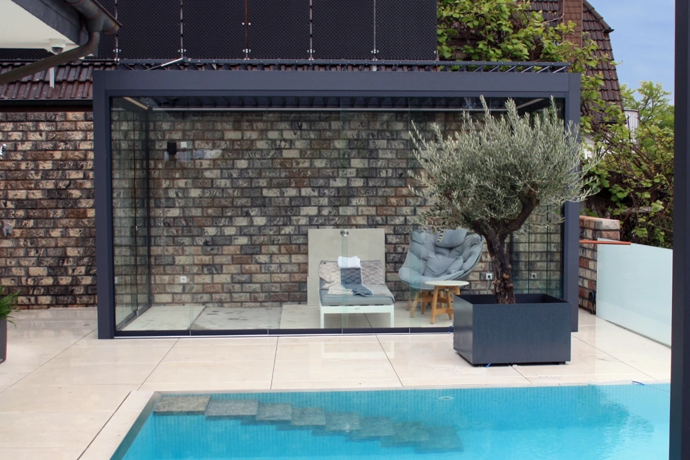 Ogrody Zimowe – przeszklona pergola tarasowa przy basenie z meblem wypoczynkowym